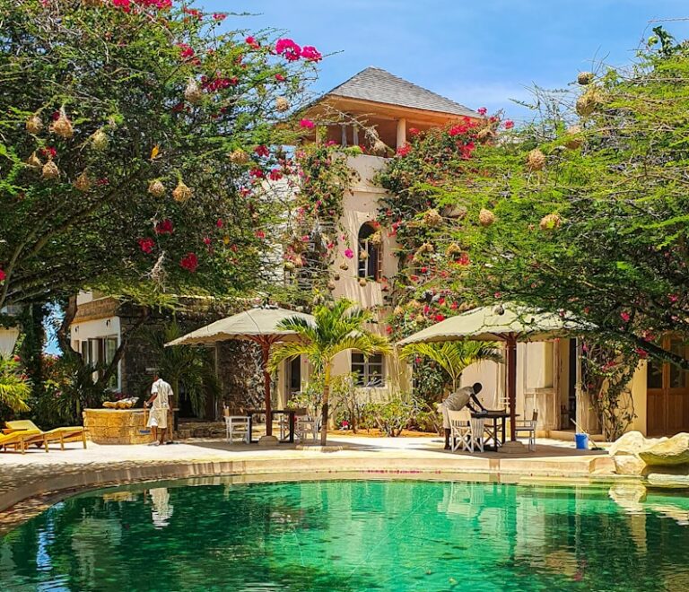 a pool surrounded by lush green trees next to a building